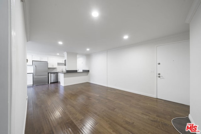 unfurnished living room with dark wood-type flooring and ornamental molding