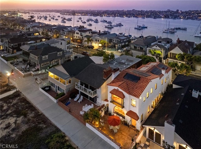 aerial view at dusk featuring a water view