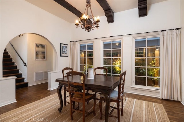 dining area with a notable chandelier, dark wood-type flooring, high vaulted ceiling, and beamed ceiling