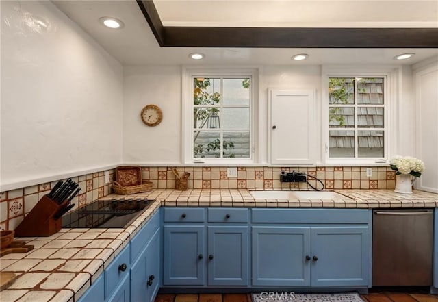 kitchen with blue cabinetry, sink, and tile counters