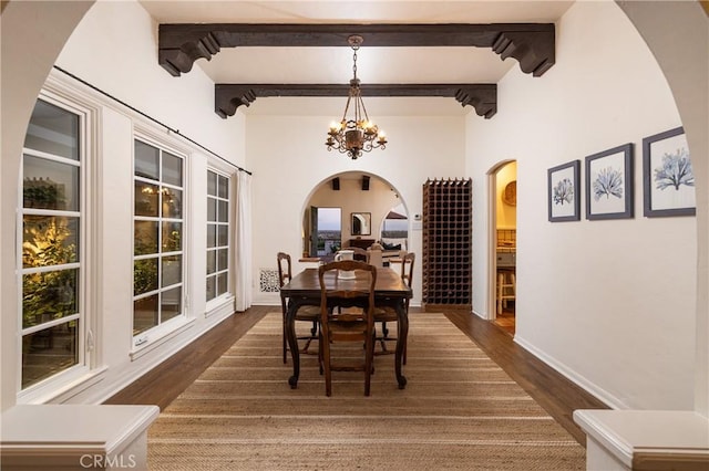 dining area with beam ceiling, dark hardwood / wood-style floors, and a notable chandelier