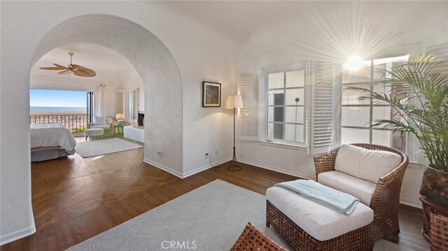 sitting room featuring dark wood-type flooring and ceiling fan