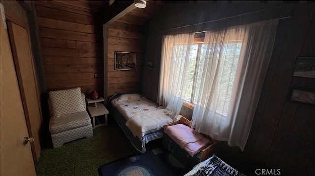 sitting room featuring lofted ceiling and wooden walls