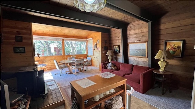 carpeted dining area with beam ceiling, wooden walls, and wooden ceiling