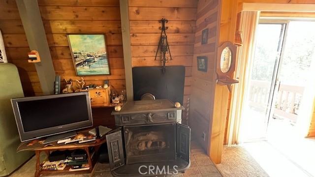 living room featuring wood walls and a wood stove