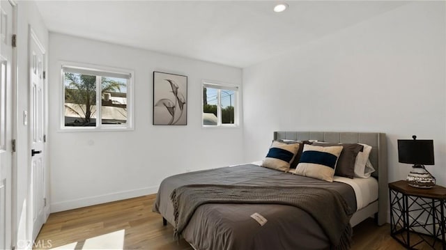 bedroom with light hardwood / wood-style flooring and multiple windows