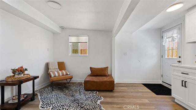 sitting room with a wealth of natural light, light hardwood / wood-style flooring, and vaulted ceiling