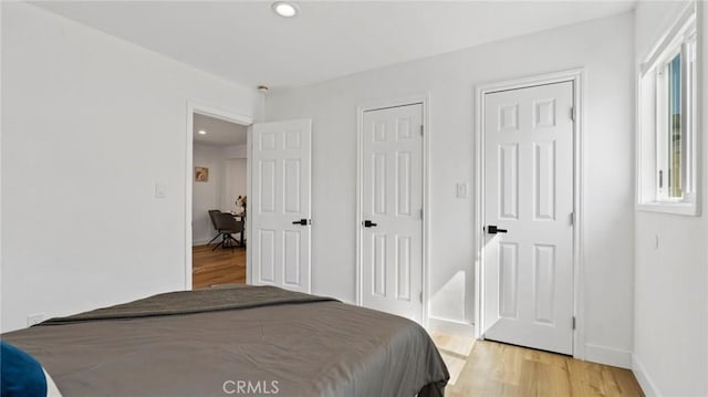 bedroom with multiple windows and light hardwood / wood-style floors