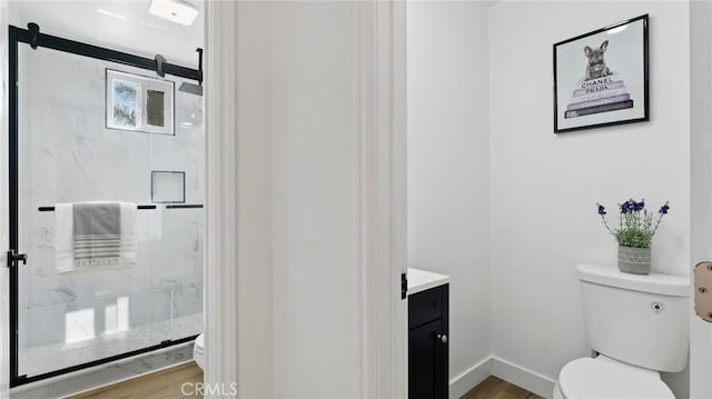 bathroom featuring an enclosed shower, vanity, toilet, and hardwood / wood-style floors