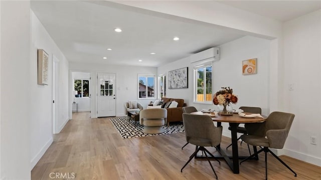 dining area featuring light hardwood / wood-style flooring and a wall mounted air conditioner