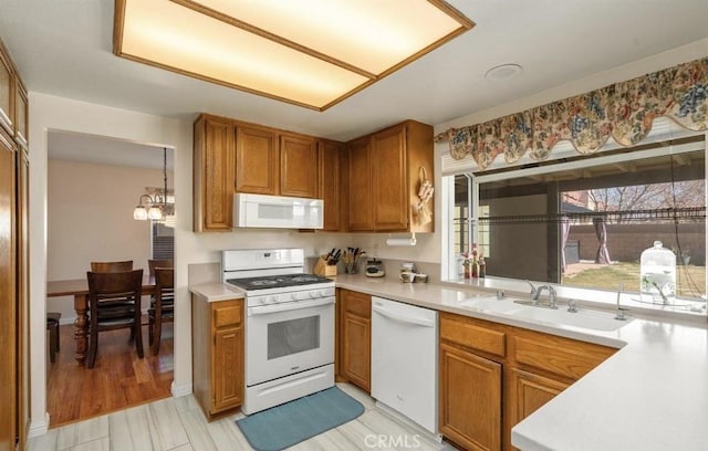 kitchen with sink, white appliances, and a chandelier