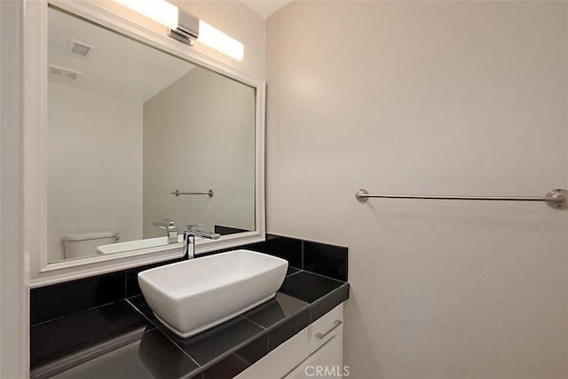 bathroom featuring toilet and vanity