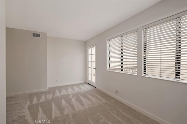 spare room featuring light colored carpet