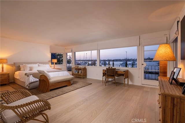 bedroom featuring access to exterior and light wood-type flooring