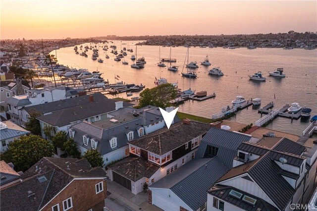 aerial view at dusk featuring a water view