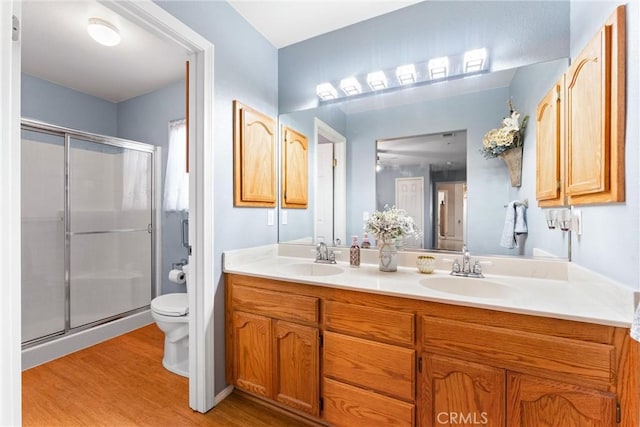 bathroom featuring a shower with shower door, wood-type flooring, toilet, and vanity