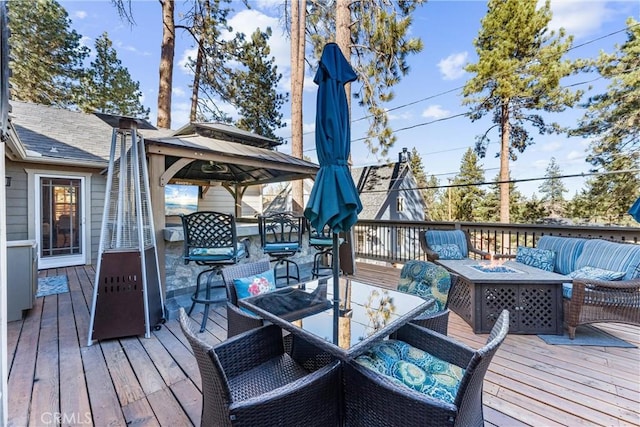 wooden deck with an outdoor living space with a fire pit