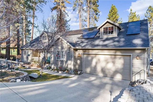 view of front of home featuring solar panels and a garage