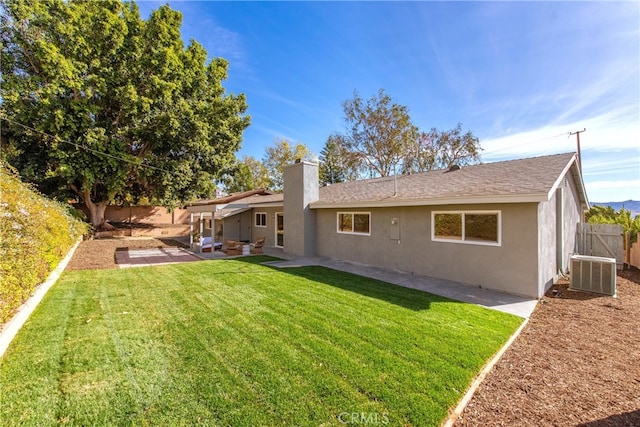 rear view of house featuring a patio area, a yard, and central air condition unit