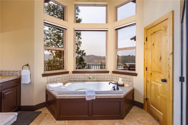 bathroom with vanity, tile patterned flooring, a healthy amount of sunlight, and a tub