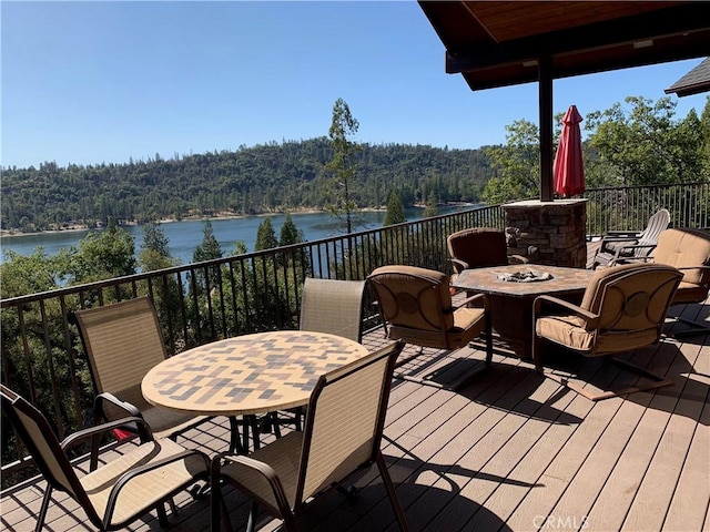 wooden deck featuring an outdoor fire pit and a water view