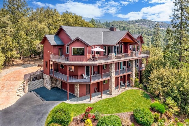 back of house with a garage, a wooden deck, and a yard