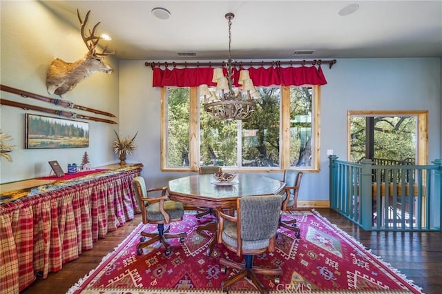 dining area with an inviting chandelier and dark hardwood / wood-style floors