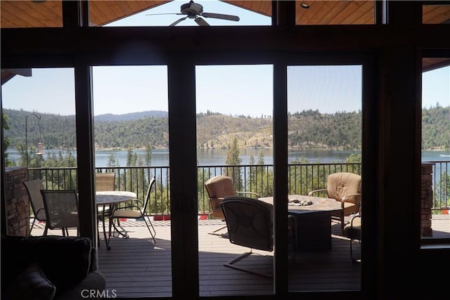 sunroom with vaulted ceiling, ceiling fan, and a water view