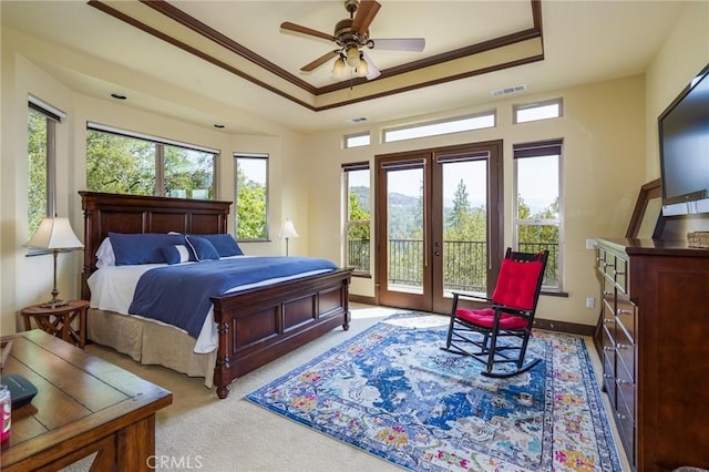 carpeted bedroom featuring ceiling fan, access to exterior, crown molding, and a raised ceiling