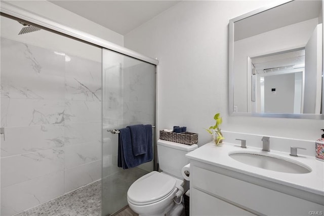 bathroom featuring toilet, a tile shower, and vanity