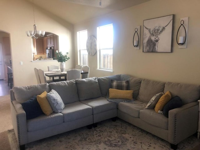 living room featuring lofted ceiling and a notable chandelier