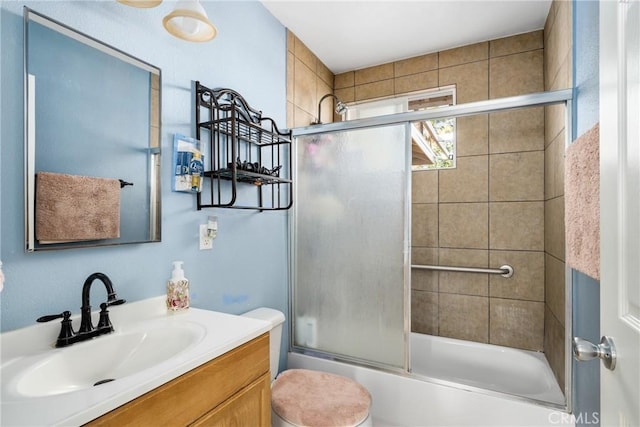 full bathroom featuring shower / bath combination with glass door, vanity, and toilet