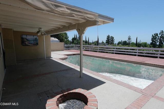 view of pool featuring ceiling fan, a patio area, and a fire pit