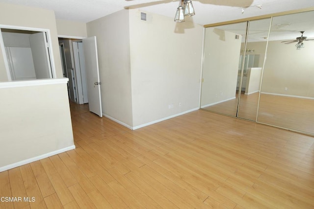 unfurnished bedroom with ceiling fan, a closet, and light hardwood / wood-style floors