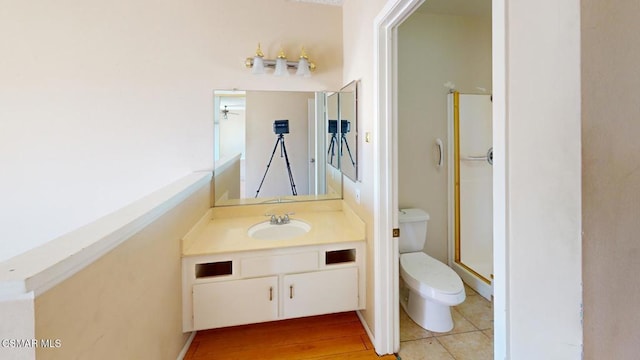 bathroom featuring toilet, tile patterned flooring, a shower with door, and vanity