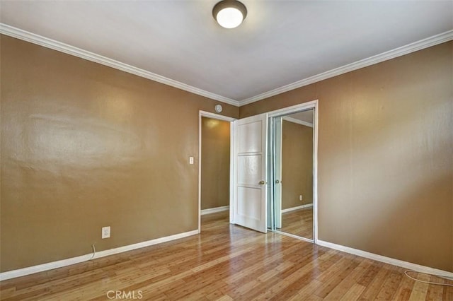 unfurnished bedroom with wood-type flooring, a closet, and ornamental molding