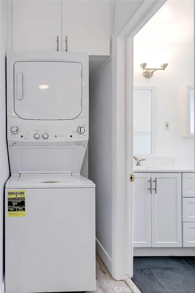 clothes washing area with sink and stacked washer and clothes dryer