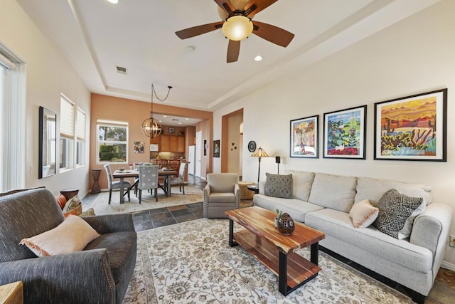 living room with ceiling fan with notable chandelier