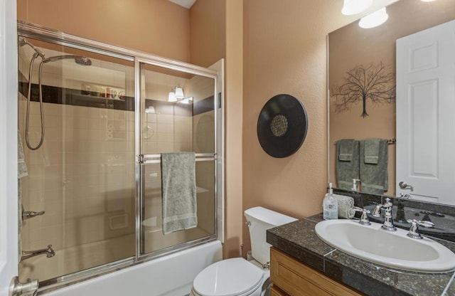 full bathroom featuring toilet, enclosed tub / shower combo, and vanity