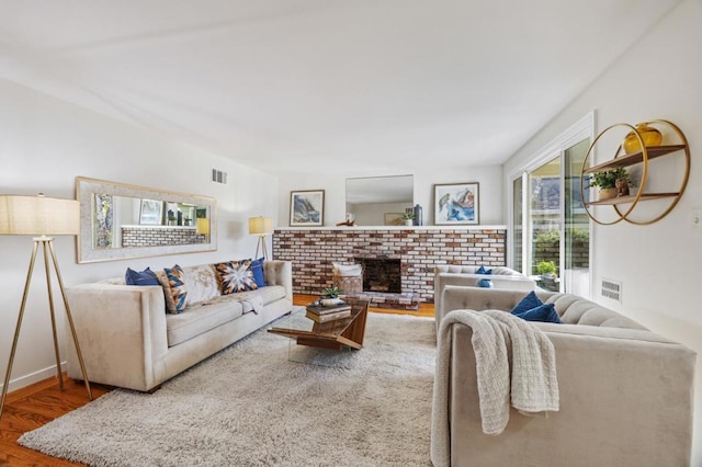 living room with a fireplace and wood-type flooring