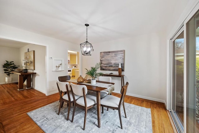 dining space with a chandelier and light hardwood / wood-style floors