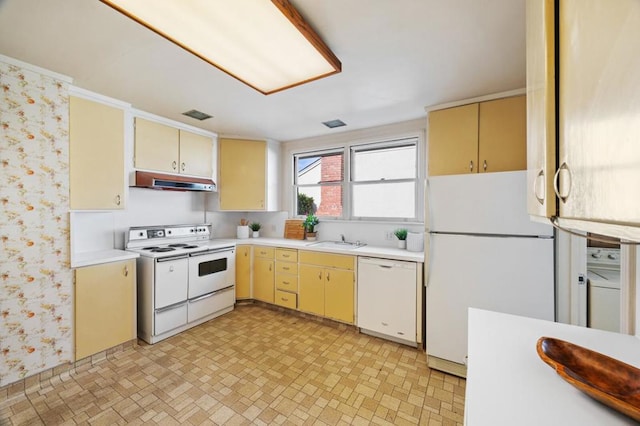 kitchen with sink, white appliances, and washer / dryer