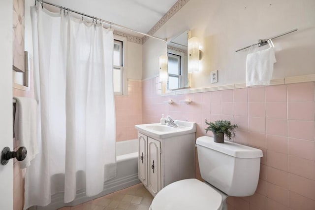 full bathroom with shower / bath combo, vanity, toilet, and tile walls