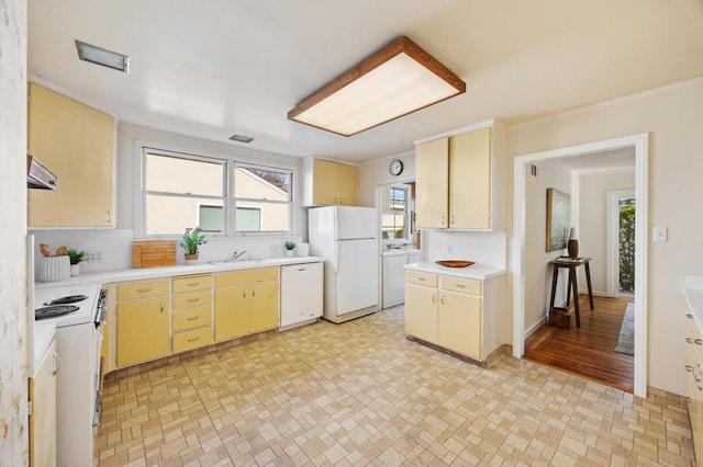 kitchen featuring ventilation hood, white appliances, washer / clothes dryer, and sink