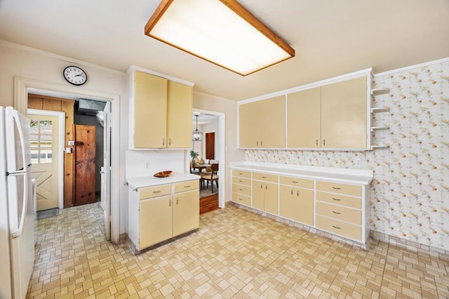 kitchen with crown molding and white refrigerator