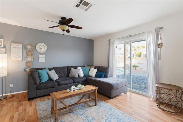 living room with ceiling fan and light hardwood / wood-style flooring