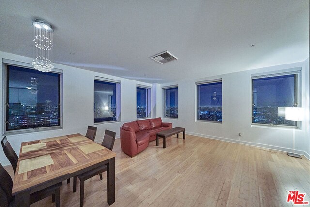 living room with an inviting chandelier and light hardwood / wood-style flooring