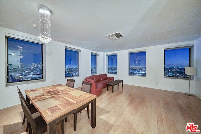 dining room with a notable chandelier and light wood-type flooring