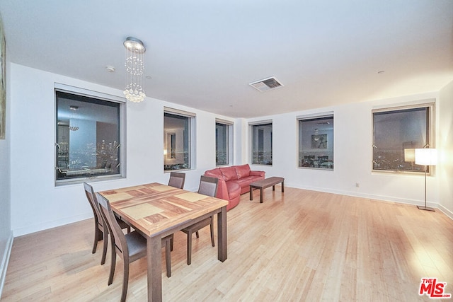 dining room featuring light hardwood / wood-style flooring and a notable chandelier