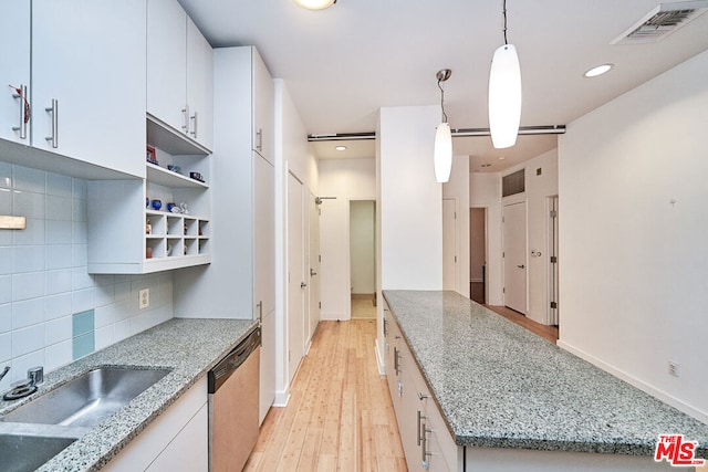 kitchen featuring backsplash, white cabinets, light stone counters, and decorative light fixtures